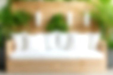 Beyaz yastıklar ve canlı yeşil bitkiler içeren rahat bir oturma düzeni keşfedin. Rahatlamak için sakin ve davetkar bir atmosfer yaratın..