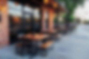 Ahşap masa ve sandalyelerin bulunduğu sakin bir teras yemek alanı. Güzel bir günbatımında günlük toplantılar ve rahatlama için mükemmel..