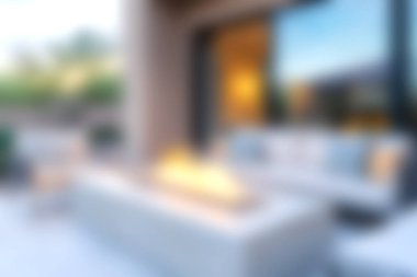 Modern bir ateş çukurunun bulunduğu sakin bir açık hava salonu keşfet, toplanmak için mükemmel. Yumuşak ışıklandırma davetkar atmosferi güçlendirir, rahatlamayı sağlar..