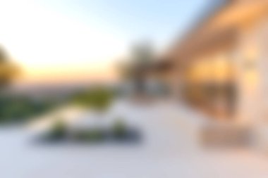 Günbatımında rahatlamak için mükemmel, şık mobilyaların yer aldığı, modern bir açık hava yaşam alanını gösteren yumuşak odaklı bir görüntü. Huzurlu bir atmosferin tadını çıkar.