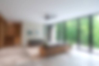 Huzurlu ve davetkar bir oturma odası, doğal ışığın mekanı aydınlatmasına izin veren geniş pencereler sergiliyor. Çağdaş tasarımda şık mobilyalar ve rahat bir atmosfer yaratmak için asgari dekor yer alıyor..