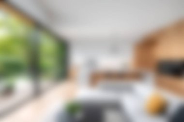 Bu resim, geniş pencereli modern bir minimalist oturma odasını gösteriyor. Doğal ışık sunuyor, rahat ve şık bir atmosfer yaratıyor..