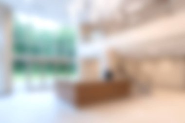 Bu resim modern bir lobiyi gösteriyor şık mobilyalar, bol doğal ışık, ve serin bir yeşillik manzarası, hoş bir atmosfer yaratıyor.