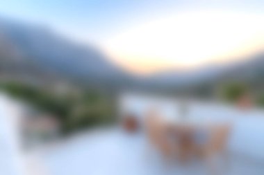 Rahat bir balkondan sakin bir gün batımı manzarası, arka planda dağlar ve dinlenmek için mükemmel sakin bir atmosfer..