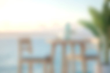 Gün doğumunda okyanusa bakan rahat sandalyelerin olduğu sakin bir sahil manzarası. Sıcak ve huzurlu atmosfer mükemmel bir rahatlama noktası yaratır..