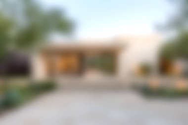 Şık mimari ve canlı yeşillik içeren modern bir konutun çarpıcı manzarası. Davetkar giriş açık havada yaşamanın güzelliğini vurguluyor..