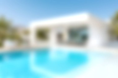 Parlak mavi gökyüzü zeminine karşı lüks bir yüzme havuzuna sahip çarpıcı modern bir villa. Rahatlama ve tatil için ideal..