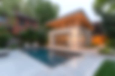 Bu resim, lüks bir yaşam ve açık hava rahatlaması sergilemek için ideal, sakin bir manzaraya karşı havuzu olan çarpıcı ve modern bir evi gösteriyor..