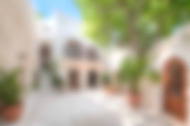 Bu resim, yemyeşil, büyüleyici mimari ve sıcak güneş ışığıyla dolu sakin bir Akdeniz avlusunu gösteriyor. Mükemmel bir açık hava inzivası yaratıyor..