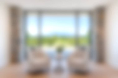 Geniş pencerelerden manzaralı, rahat ve uyum için davetkar bir atmosfer sunan parlak, modern bir oturma odası..