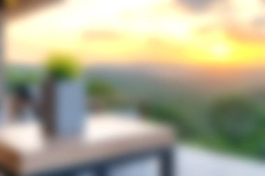 Günbatımına tepeden bakan modern bir terasın olduğu sakin bir sahne. Akşam gökyüzünün yumuşak parıltısı rahatlığı ve rahatlığı arttırır. Açık havada yaşamak için idealdir..