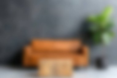 Koyu bir duvara karşı ahşap bir kanepe ve şık bir kahve masası olan rahat bir oturma odası, dinlenmek için sıcak ve davetkar bir ortam yaratıyor..