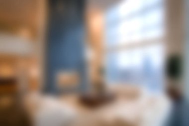 Bu yumuşak odaklı görüntü, şık bir şömine ve geniş pencereli rahat ve modern bir oturma odası yakalıyor ve rahatlamak için sıcak ve davetkar bir ortam yaratıyor..