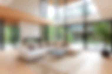 Bu resimde doğal ışıkla dolu, minimalist bir dekor ve geniş bir düzenle modern bir oturma odası sergilenmektedir. Sıcak ahşap aksanlar ve davetkar mobilyalar rahatlamak için mükemmel bir ortam yaratıyor..