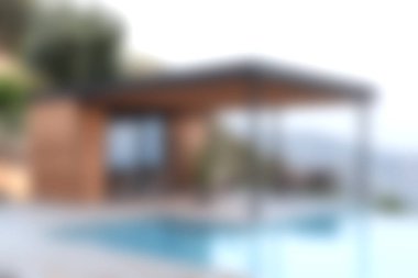 Bu resim, dingin bir havuz alanına sahip, aydınlık ve doğal bir ortamda rahatlama ve manzara için mükemmel bir yere sahip modern bir açık hava evini gösteriyor..