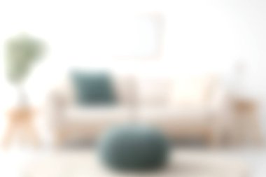 Parlak ve davetkar bir oturma odası yumuşak bir kanepe ve yumuşak bir puf, rahatlamak için mükemmel. Minimalist dekor konfor ve tarzın altını çiziyor.