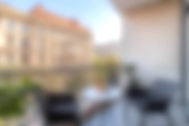 Modern mobilyalarla, yeşilliklerle dolu rahat bir balkon sahnesi ve rahatlamaya ve rahatlamaya davetiye çıkaran güzel bir şehir manzarası yaşayın..