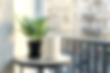 Yumuşak doğal ışıkla aydınlatılan ve rahatlama ve dekorasyon için ideal sıcak ve davetkar bir atmosfer yaratan, bir masa üzerinde saksı bitkisinin yer aldığı sakin bir sahne..