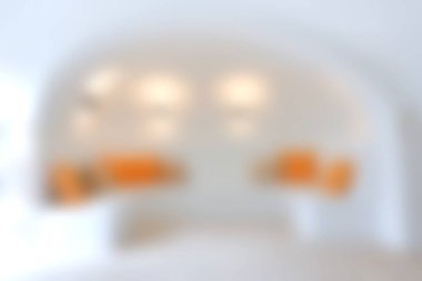 Beyaz duvarları ve canlı turuncu aksanları olan minimalist bir iç mekan. Yumuşak odak, modern dekor meraklıları için mükemmel bir sakinleştirici atmosfer yaratır..