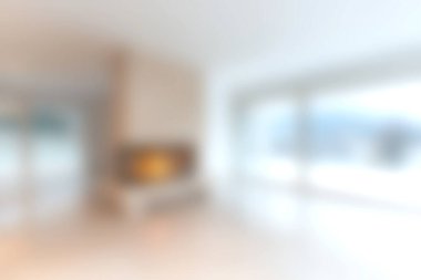 Rahat bir şömine, minimalist dekor ve bol doğal ışık içeren, rahatlama ve konfor çağrıştıran parlak bir oturma alanının yumuşak odaklı görüntüsü..