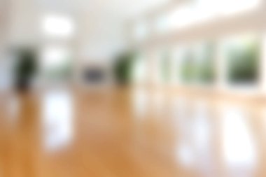 Geniş ve parlak modern bir iç mekan. Geniş pencerelerden süzülen güneş ışığı. Sıcak ve davetkar bir atmosfer yaratıyor..