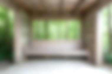 Yumuşak odaklı yemyeşil yeşilliklerle çevrili ahşap bir oturma alanı içeren barışçıl bir doğa inzivası. Rahatlama ve sükunet için ideal bir alan..