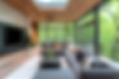 Doğal ışığı davet eden ve yeşillik manzarası sunan geniş pencereli çarpıcı bir modern oturma odası. Samimi tasarımda şık mobilyalar ve sıcak bir atmosfer yer alıyor..