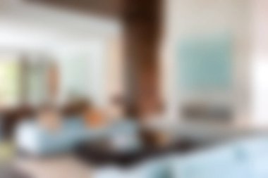 Bu resimde doğal ışıkla dolu modern bir oturma odası, rahat mobilyalar ve davetkar bir atmosfer yaratan zevkli dekorlar sergileniyor..