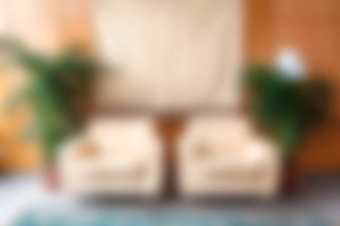 Bu rahat oturma odası sahnesinde iki tane davetkar koltuk var. Dolu iç mekan bitkileri ve sıcak ahşap duvarlarla çevrili. Rahatlamak için sakin bir atmosfer yaratıyorlar..