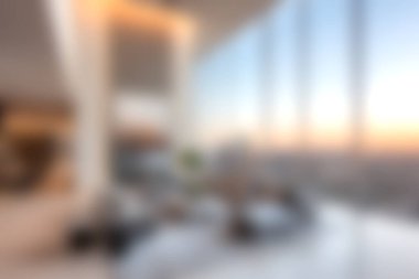 Gün batımında şehir ufkunun nefes kesici manzarasını sağlayan geniş pencereli şık bir dinlenme odası. Rahatlamak için mükemmel..