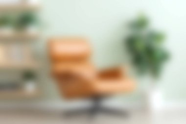 Kapalı bir bitki tarafından tamamlanmış, rahatlatıcı yeşil bir duvara yerleştirilmiş rahat, deri bir döner sandalye, her türlü modern yaşam alanına cazibe katar..