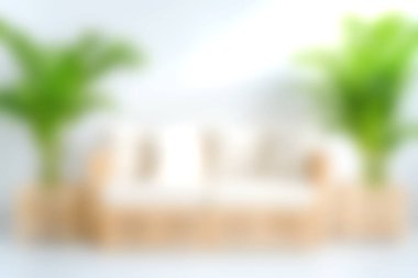 Bu görüntüde, doğal ışıkla dolu sakin ve davetkar bir atmosfer yaratan tarafsız bir kanepenin yer aldığı rahat bir oturma odası var..