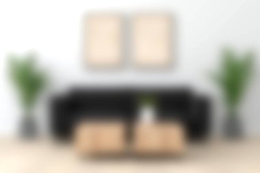 Modern siyah bir kanepe, ahşap bir sehpa ve canlı yeşil bitkilerin bulunduğu şık bir oturma odası. Çağdaş ev dekorasyonu için ideal.