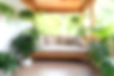 Bu resim, yeşil bitkilerle ve bol doğal ışıkla dolu, modern bir evde rahatlık ve rahatlık için mükemmel bir kapalı alan içeriyor..