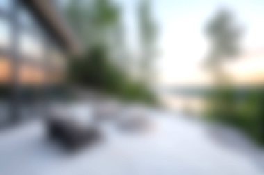 Günbatımında yemyeşil bir manzarayla çevrili modern mobilyaların bulunduğu sakin bir açık hava salonu, rahatlamak ve kaçmak için mükemmel bir yer..