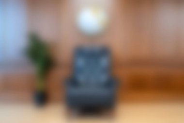 Çağdaş bir odada, ahşap bir duvar ve dekoratif bir bitkinin bulunduğu gösterişli bir masaj koltuğu. Rahatlık ve refahı desteklemek için ideal..