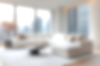 Bu resim, mekanı doğal ışıkla dolduran ve sakin bir atmosfer yaratan geniş pencereli modern bir oturma odasını gösteriyor..