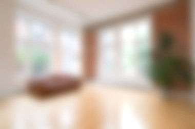 Parlak güneş ışığıyla yıkanmış rahat bir oturma odasında geniş pencereler, ahşap döşemeler, modern mobilyalar ve rahatlama ve rahatlama için mükemmel bir karşılama atmosferi bulunur..