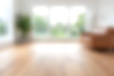 Sessiz bir oturma odasında geniş pencereler sergileniyor. Sıcak ahşap döşemeler ve modern mobilyalarla aydınlatılan doğal ışıkla..