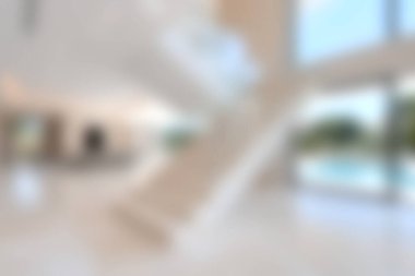 Bu resim modern, minimalist bir iç tasarım sergiliyor zarif bir merdiven, parlak bir açık alan ve bol doğal ışık, şık bir ortam yaratıyor..