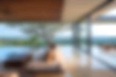 Bu resim, içerideki zarafetle dışarıdaki sükuneti harmanlayan, panoramik manzaralı ve havuz başında sakin bir atmosferi olan modern lüks bir oturma odasını gösteriyor..