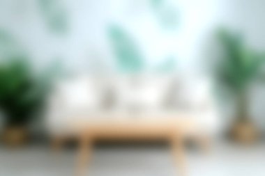 Huzurlu ve davetkar bir oturma odası yumuşak yastıklarla süslenmiş, yemyeşil bitkilerle tamamlanmış, taze ve şık bir atmosfer yaratan modern bir kanepe sunuyor..