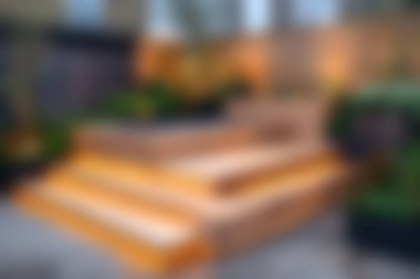 Parlak turuncu aksanla süslenmiş ahşap basamaklar gür bir açık hava bahçesinde canlı bir odak noktası oluşturuyor. Huzur ortamı gevşemeyi ve bahçe estetiğini arttırıyor..