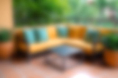 Berrak yeşil bitkilerle çevrili, rahat ve rahat bir koltuğu olan sakin bir açık hava oturma alanı ve sakin bir atmosfer yaratmak için doğal ışık..