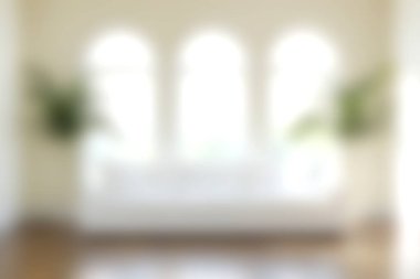 Yumuşak beyaz bir kanepesi ve çarpıcı kemerli pencereleri olan parlak ve havadar bir oturma odası. Doğal ışık, ferahlatıcı bir ortam için dekoratif yeşillik ile güçlendirilmiş alanı doldurur..