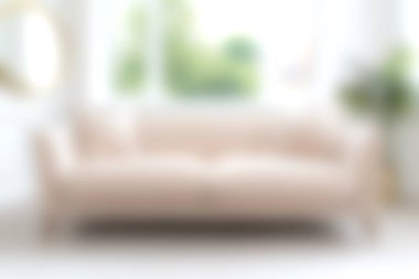 Yumuşak bej bir kanepenin olduğu, doğal ışıkla dolu ve yeşillikle süslenmiş, davetkar ve sakin bir atmosfer yaratan rahat bir minimalist oturma odası..