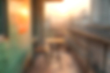 Şehir balkonundan izlenen bir güneşin sakin ve yumuşak odağı, sıcak bir ışık ve davetkar bir şehir manzarası. Rahatlama temaları için mükemmel.