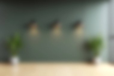 Rahatlatıcı yeşil bir duvar, zarif ışık armatürleri ve yemyeşil bitkiler içeren modern bir iç mekan, rahatlama ve ilham için mükemmel sakin bir atmosfer yaratıyor..