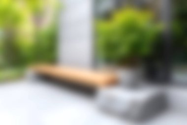 Yeşillikler arasında modern ahşap bir bankın yer aldığı rahat bir şehir bahçesi keşfedin. Bu dingin alan rahatlama ve sükuneti davet ediyor, rahatlık için mükemmel..