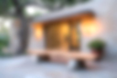 Yumuşak ışıklandırma, bulanık arka plan ve yemyeşil, modern mimari ve barışçıl ortam içeren sakin ve davetkar bir açık hava girişi..